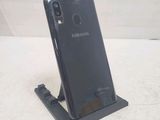 the back of a black samsung phone with a charging dock attached to it