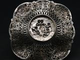 a close up of a silver plate with a picture of a man and a woman on it