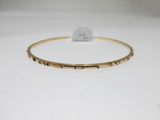 un bracelet rigide en or sur lequel est gravé le mot « love »