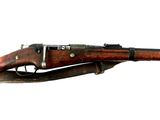 un fusil sur fond blanc, avec des coupures de presse sur le côté