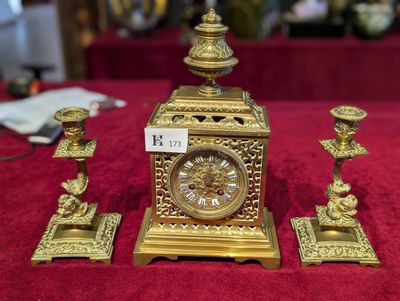 une horloge dorée posée sur une table rouge