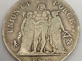 an image of a silver coin with the image of a woman and two men