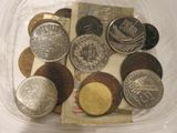 de nombreuses pièces de monnaie dans un récipient en plastique posé sur une table