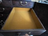 a person opening a wooden drawer with a handle
