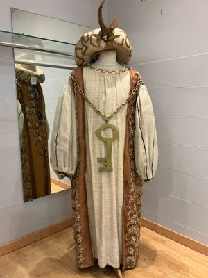 un mannequin dans une pièce avec un miroir et des vêtements exposés