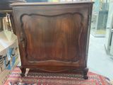 a wooden cabinet that is sitting on a rug