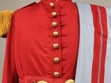 an image of a red uniform with gold buttons and a blue and white scarf