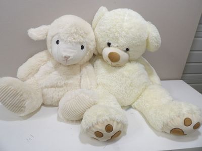 two white teddy bears sitting on a white table