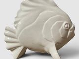 un poisson en céramique blanche posé sur une table