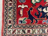 an oriental rug with a red background and blue and green designs