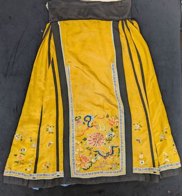 an old yellow skirt with black trim sitting on top of a table