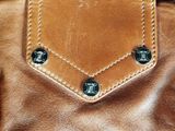 a brown leather purse with two buttons on it