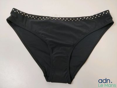 un gros plan sur une culotte noire ornée de perles sur le bas