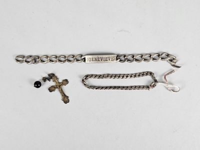 a close up of a chain bracelet with a cross on it