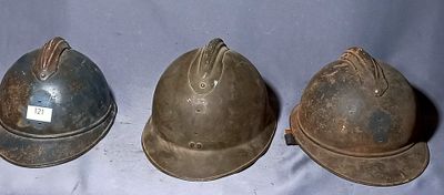 three helmets are lined up on a white surface