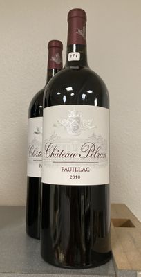 three bottles of red wine sitting on top of a wooden block