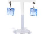 blue crystal square earrings on a clear display stand