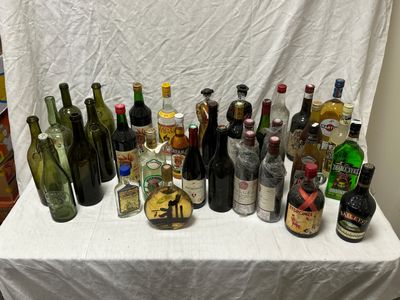 de nombreuses bouteilles d'alcool posées sur une table recouverte d'une nappe blanche