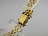 une image montrant un gros plan d'une montre posée sur une surface transparente