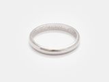gros plan d'une bague en argent sur une surface blanche