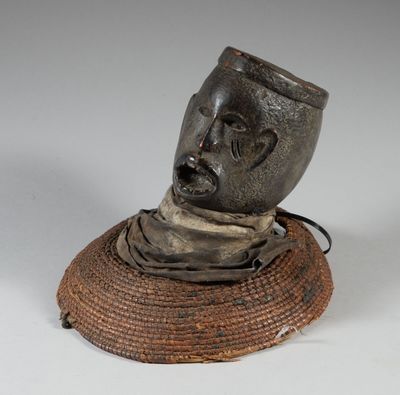 une sculpture représentant une tête d'homme posée sur un panier