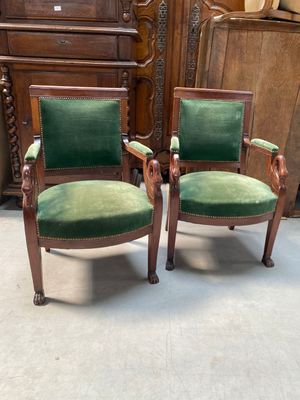 pair of green velveted chairs in a room with a wooden cabinet