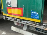 un camion vert et jaune garé sur le bord de la route