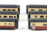 two toy trains sitting next to each other on a white surface
