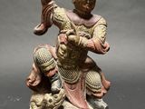 an image of a statue of a man with a sword on a rock