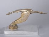 statue d'un oiseau posée sur un socle en marbre, sur une surface blanche