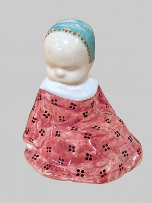a figurine of a woman wearing a pink dress and a blue headband