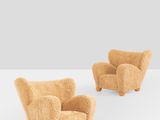 two chairs made out of wool and wood, one with a foot rest