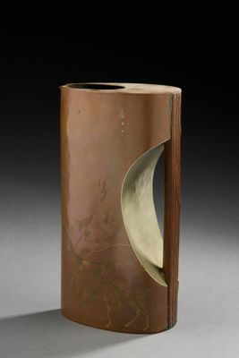 un vase marron orné d'un motif, posé sur une table