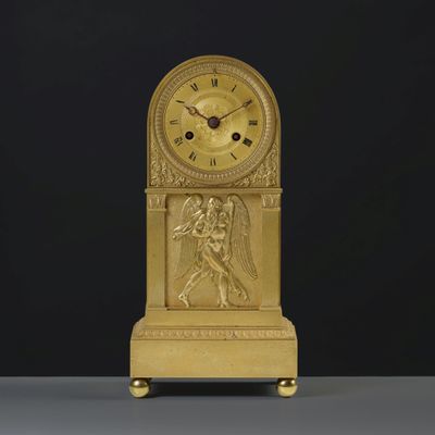 a gold clock that is sitting on a table