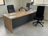 un bureau avec un ordinateur et une chaise dans une pièce
