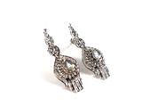 paire de boucles d'oreilles argentées ornées de cristaux sur fond blanc