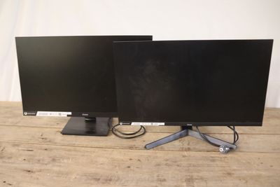 deux écrans d'ordinateur posés sur une table en bois
