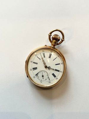 une montre de poche en or avec des chiffres romains