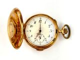 a gold pocket watch with the eiffel tower in the background