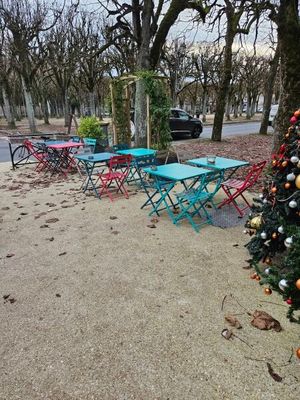 de nombreuses tables et chaises près d'un sapin de Noël sur le trottoir