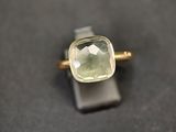 une bague sertie d'une pierre verte, posée sur une table
