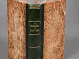 an old book with a green cover on a table