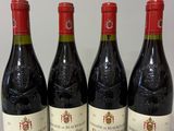 quatre bouteilles de vin sont alignées sur une table