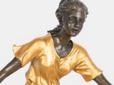 bronze statue of a woman holding a tennis racquet on a white surface