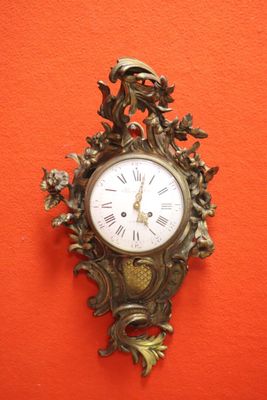 a clock hanging on the wall with a bird on it