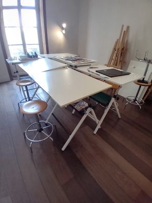 une photo d'une pièce avec une table et des tabourets