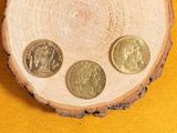 three coins sitting on top of a piece of wood