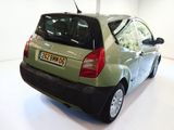 a small green car parked in a white room