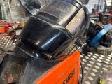 a helmet on the back of a moped in a garage