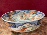 a bowl that is sitting on a table with a red wall in the background